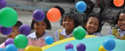 Children outside a kindergarten in Thailand play with colourful balls during a physical activity led by Projects Abroad Childcare volunteers. Projects Abroad volunteers in Thailand do outdoor activities with children at a kindergarten in Thailand.